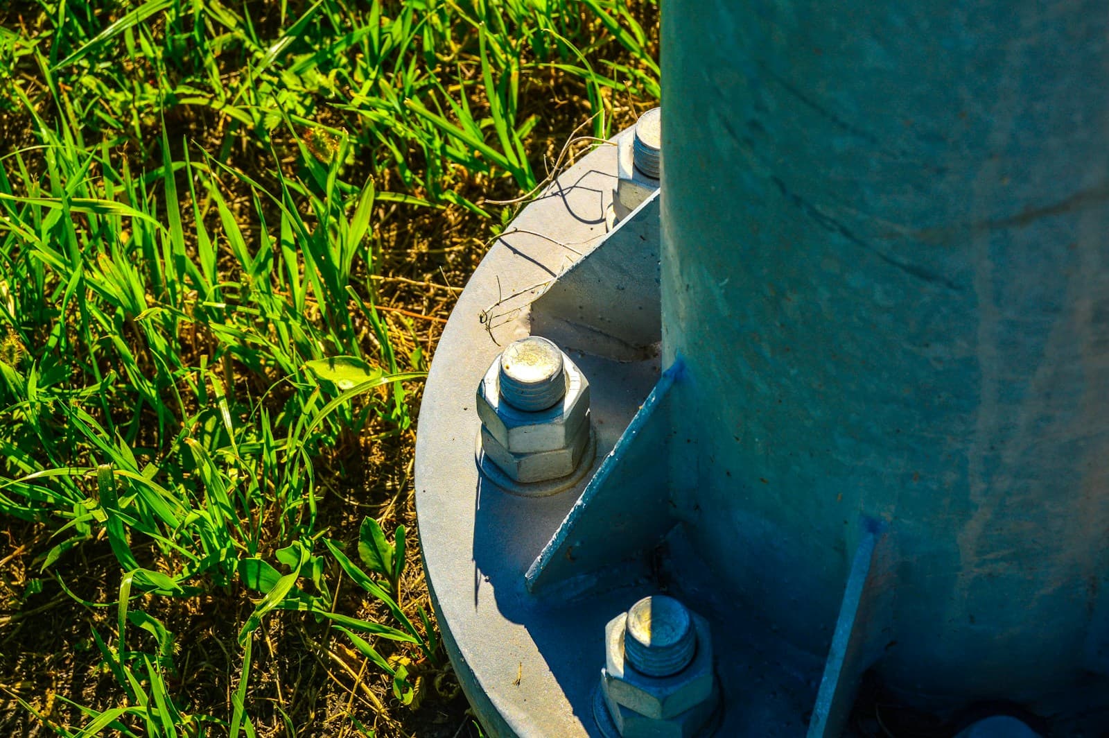 Närbild av en galvaniserad stålförankring i marken